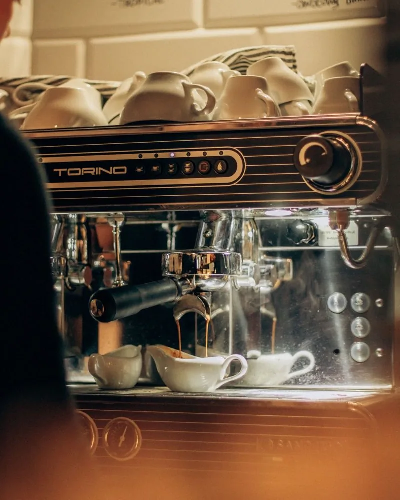 Ріжкова кавомашина готує espresso за барною стійкою кав'ярні